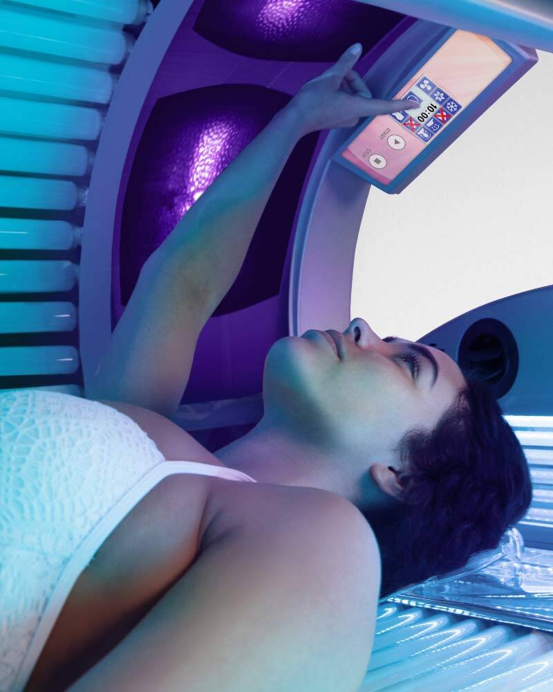 woman inside an Ultrasun Q18 Hybrid tanning bed